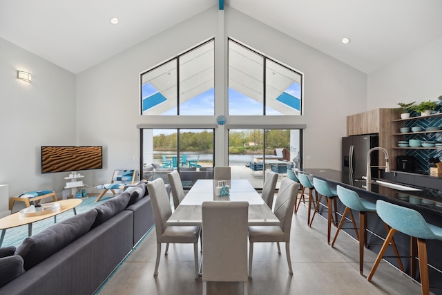 7469 Lake Solis Dr, Stevensville, MI 49127 - dining area featuring high vaulted ceiling, finished concrete floors, and recessed lighting