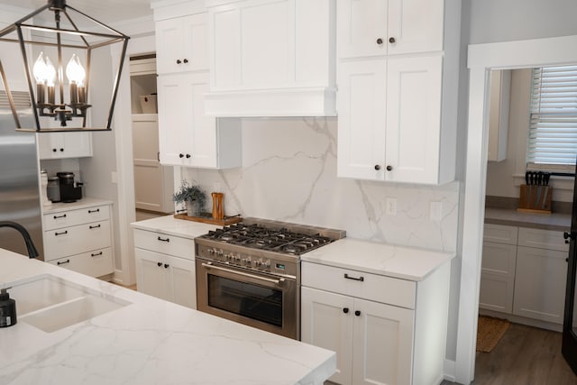 8182 Country Rail Dr SW, Byron Center, MI 49315 - kitchen featuring high end stainless steel range oven, tasteful backsplash, white cabinetry, and a chandelier