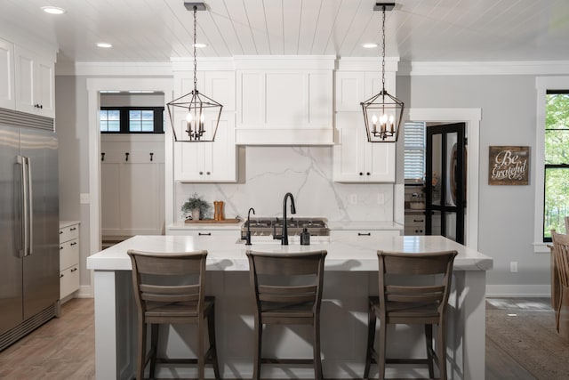 8182 Country Rail Dr SW, Byron Center, MI 49315 - kitchen with built in fridge, a chandelier, backsplash, recessed lighting, and crown molding