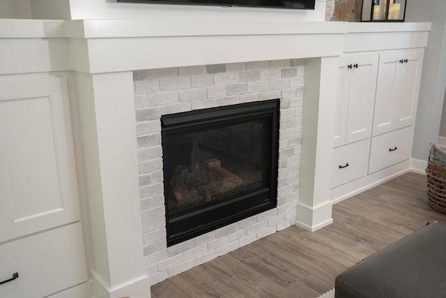 8182 Country Rail Dr SW, Byron Center, MI 49315 - detailed view of wood finished floors, a brick fireplace, and baseboards