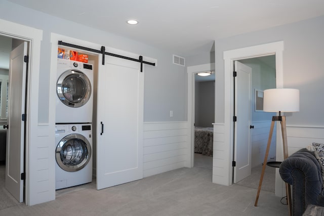 8182 Country Rail Dr SW, Byron Center, MI 49315 - laundry room with stacked washer / drying machine, a barn door, carpet flooring, a wainscoted wall, and wood walls