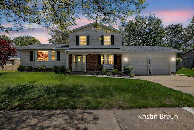 view of front of house with a garage, concrete driveway, a front lawn, covered porch, and brick siding