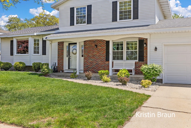 traditional home featuring brick siding, a front yard, covered porch, and a shingled roof
