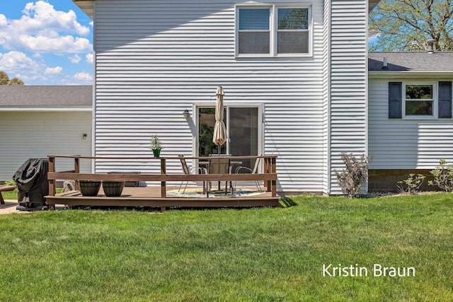 rear view of house with a wooden deck and a yard