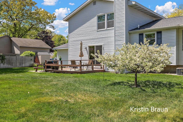 back of property featuring a storage shed, a wooden deck, and an outdoor structure