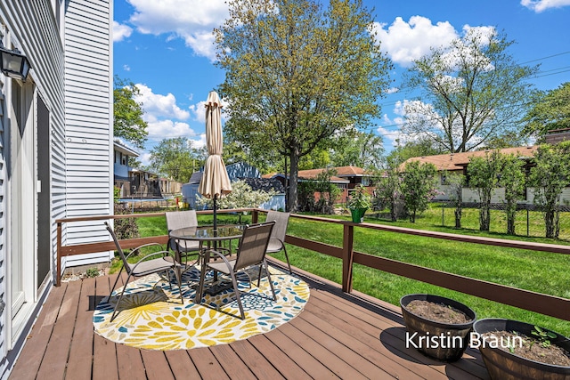 wooden terrace with a trampoline and outdoor dining area