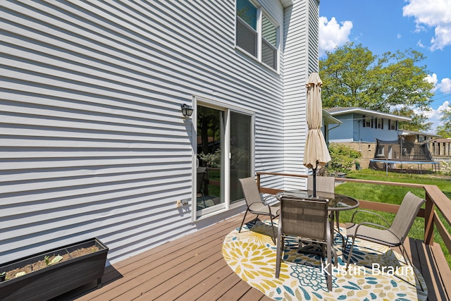 deck with a trampoline and outdoor dining space