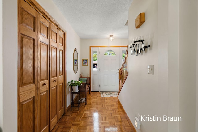 entryway with a textured ceiling and baseboards