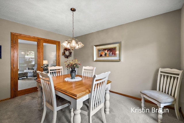 carpeted dining room featuring baseboards and a chandelier