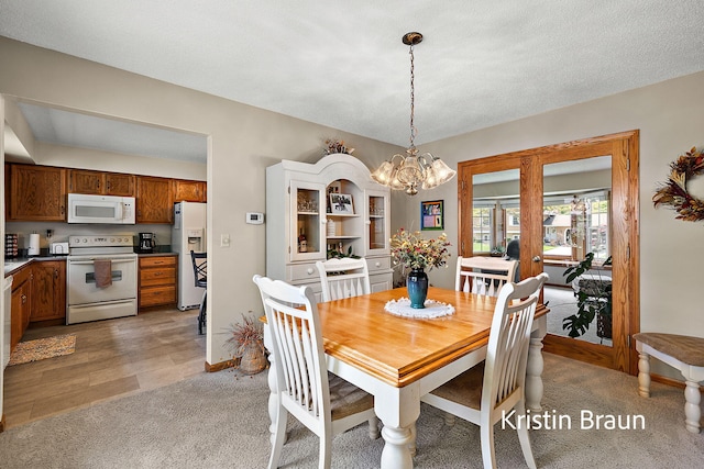 dining space with a chandelier and light carpet