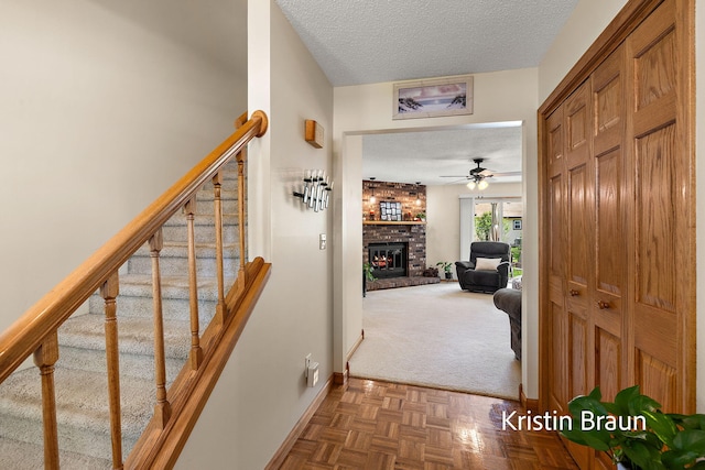 corridor with a textured ceiling, baseboards, stairs, and carpet