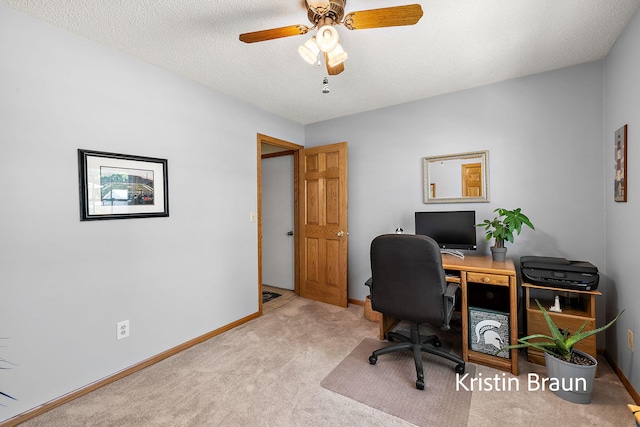 carpeted home office featuring baseboards, ceiling fan, and a textured ceiling