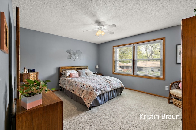 carpeted bedroom featuring baseboards, a ceiling fan, and a textured ceiling