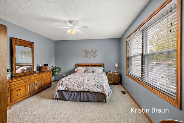 bedroom with carpet, a textured ceiling, a ceiling fan, and baseboards