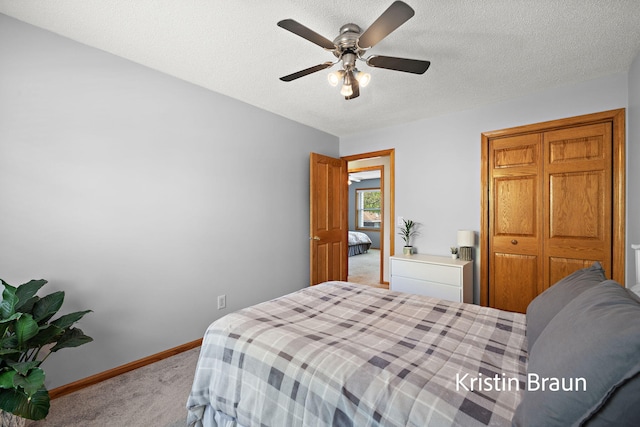 carpeted bedroom with baseboards, ceiling fan, and a textured ceiling