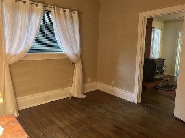1902 W Ogilvie Ave, Baldwin, MI 49304 - unfurnished room featuring wood finished floors, a wood stove, and baseboards