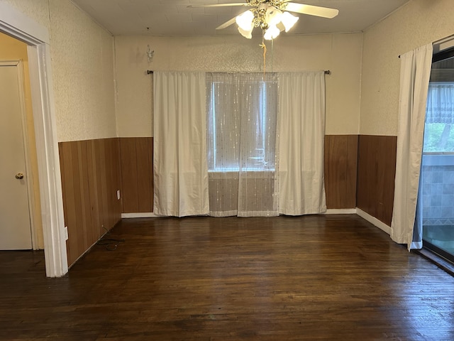 1902 W Ogilvie Ave, Baldwin, MI 49304 - unfurnished room featuring dark wood-style floors, a textured wall, a ceiling fan, a wainscoted wall, and wooden walls