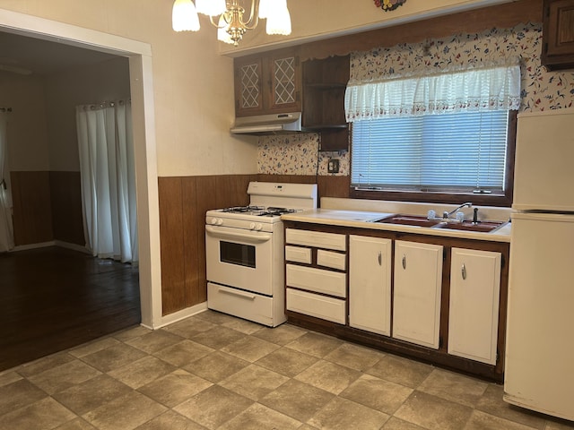 1902 W Ogilvie Ave, Baldwin, MI 49304 - kitchen with white appliances, a sink, a wainscoted wall, a chandelier, and under cabinet range hood