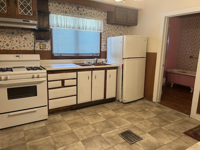 1902 W Ogilvie Ave, Baldwin, MI 49304 - kitchen with white appliances, a sink, wallpapered walls, under cabinet range hood, and light countertops