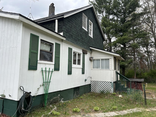 1902 W Ogilvie Ave, Baldwin, MI 49304 - view of side of property with a chimney, roof with shingles, crawl space, and entry steps