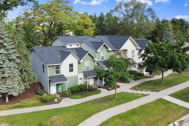 2951 Vineland Ave SE, Grand Rapids, MI 49508 - view of front of home featuring a garage, a front yard, roof with shingles, and view of scattered trees