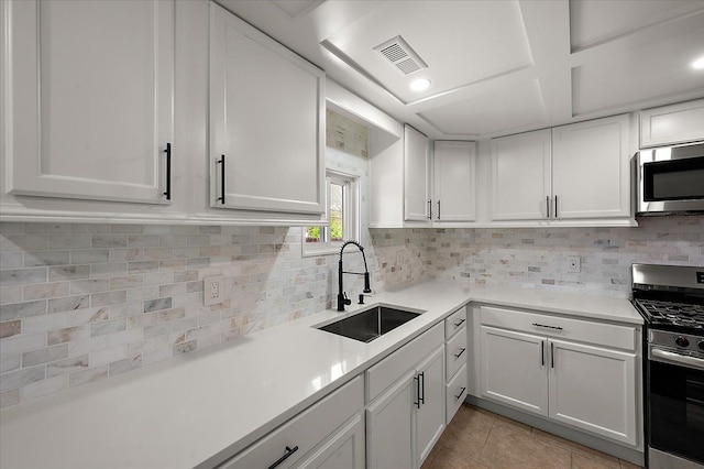 13665 Ida Ave, Warren, MI 48089 - kitchen featuring stainless steel appliances, a sink, tasteful backsplash, white cabinets, and light countertops