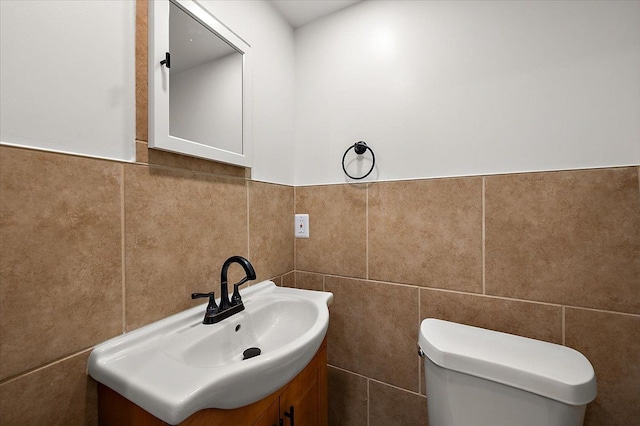 13665 Ida Ave, Warren, MI 48089 - half bathroom featuring tile walls, toilet, vanity, and a wainscoted wall