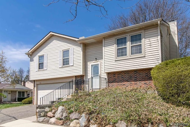 2975 Roundtree Dr, Troy, MI 48083 - bi-level home featuring an attached garage, driveway, and brick siding