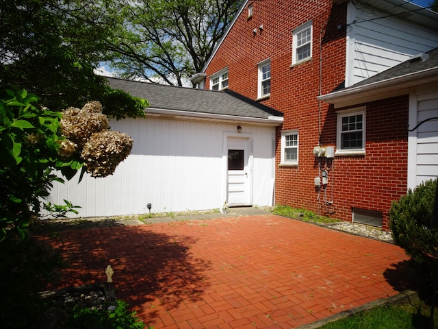 back of property featuring a patio and brick siding