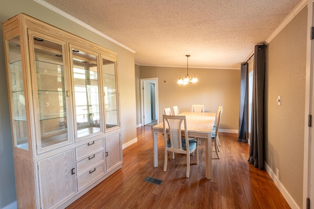 2330 N Rath Rd, Ludington, MI 49431 - dining room featuring ornamental molding, dark wood-style flooring, a chandelier, a textured ceiling, and baseboards