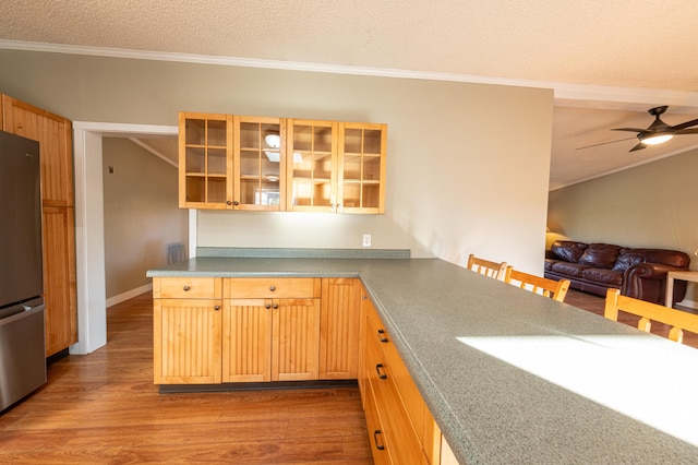 2330 N Rath Rd, Ludington, MI 49431 - kitchen with freestanding refrigerator, crown molding, wood finished floors, open floor plan, and glass insert cabinets