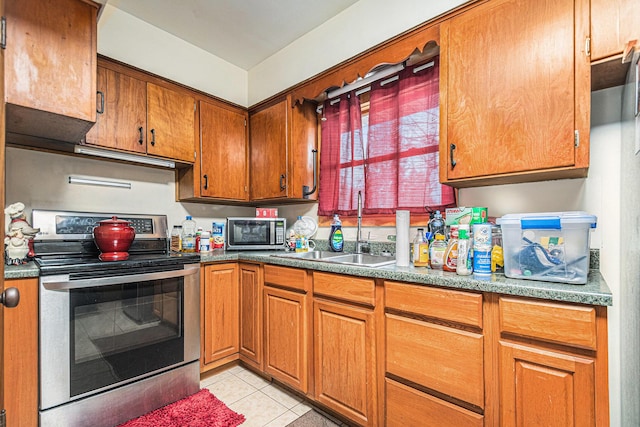 1772 Lombard St, Benton Harbor, MI 49022 - kitchen with appliances with stainless steel finishes, a sink, light tile patterned floors, and brown cabinets