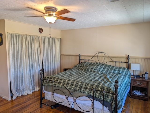120 N Main St, Scottville, MI 49454 - bedroom featuring a wainscoted wall, wood-type flooring, and a ceiling fan