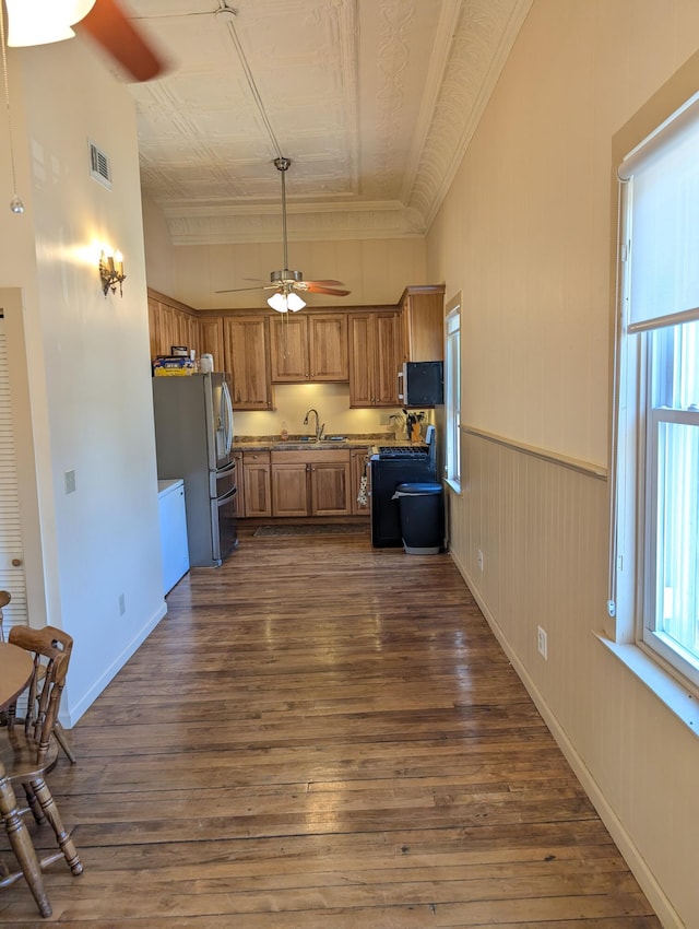 120 N Main St, Scottville, MI 49454 - kitchen featuring a ceiling fan, brown cabinetry, stainless steel appliances, a sink, and dark wood-style floors
