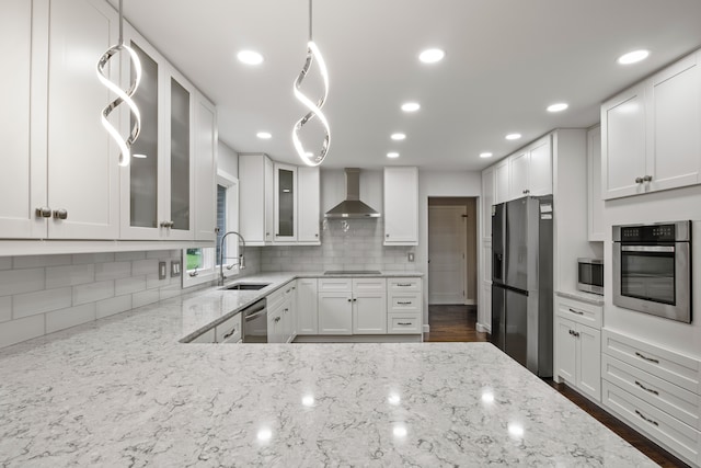 4578 Pine Village Dr, West Bloomfield, MI 48323 - kitchen featuring stainless steel appliances, a sink, wall chimney range hood, tasteful backsplash, and glass insert cabinets