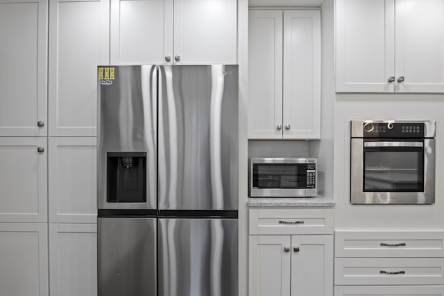 4578 Pine Village Dr, West Bloomfield, MI 48323 - kitchen featuring stainless steel appliances, white cabinets, and light stone countertops
