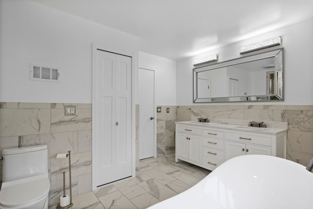 4578 Pine Village Dr, West Bloomfield, MI 48323 - bathroom featuring tile walls, wainscoting, marble finish floors, a soaking tub, and vanity