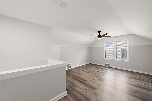 bonus room with lofted ceiling, a ceiling fan, dark wood finished floors, and baseboards