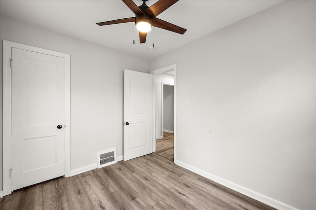 unfurnished bedroom featuring baseboards, wood finished floors, and a ceiling fan