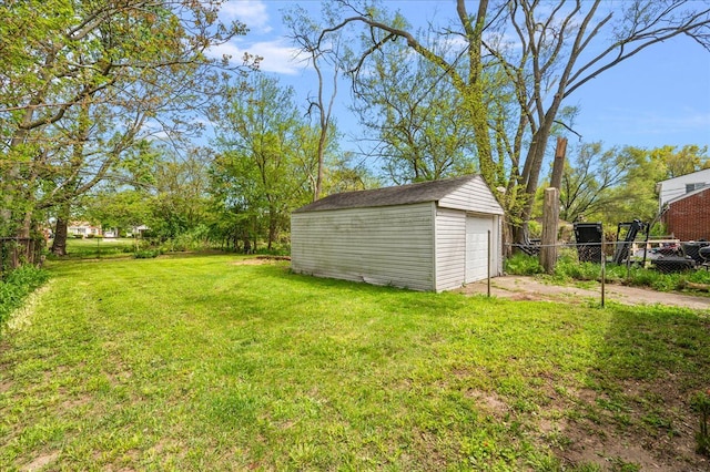view of yard with an outbuilding, a garage, and driveway