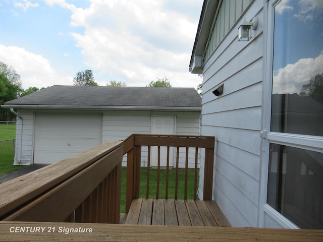 wooden terrace with a garage and a yard