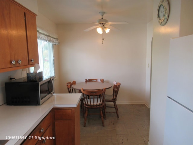 dining room featuring a ceiling fan and baseboards