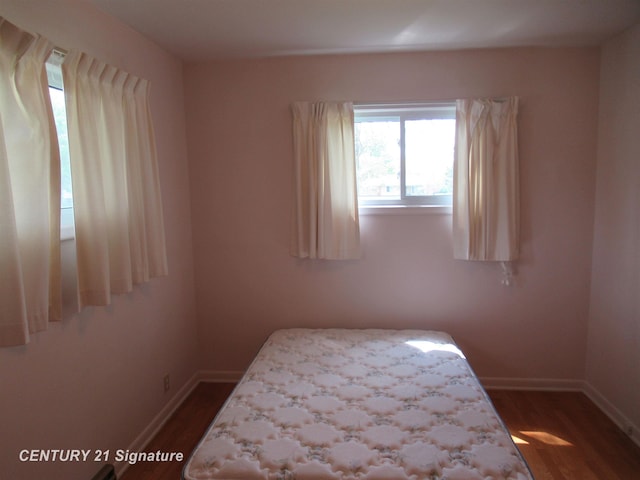 bedroom featuring dark wood-style flooring and baseboards