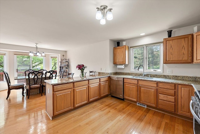 19880 Irving Dr, Livonia, MI 48152 - kitchen with stainless steel appliances, a sink, a peninsula, brown cabinetry, and light wood-style flooring