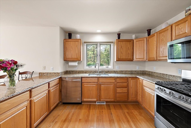 19880 Irving Dr, Livonia, MI 48152 - kitchen featuring appliances with stainless steel finishes, a sink, light stone countertops, light wood-type flooring, and recessed lighting