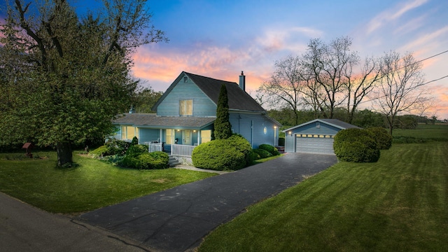 204 Parker St, Cement City, MI 49233 - view of front of house featuring an outbuilding, a garage, covered porch, a chimney, and a lawn