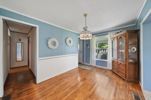 204 Parker St, Cement City, MI 49233 - unfurnished dining area with hardwood / wood-style floors, a chandelier, crown molding, and baseboards
