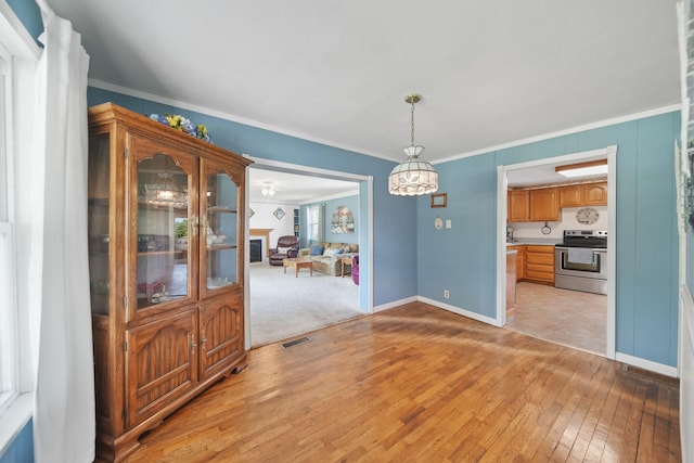 204 Parker St, Cement City, MI 49233 - unfurnished dining area with light wood-style flooring, baseboards, and crown molding