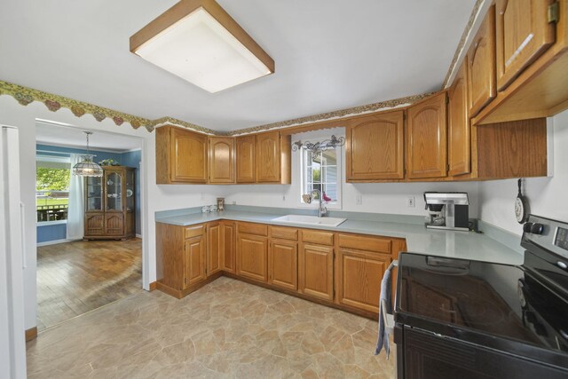 204 Parker St, Cement City, MI 49233 - kitchen with range with electric cooktop, a sink, brown cabinets, light countertops, and light stone finish floors