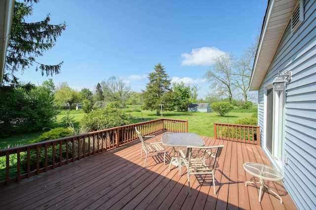 204 Parker St, Cement City, MI 49233 - wooden deck with outdoor dining area, a lawn, and view of scattered trees